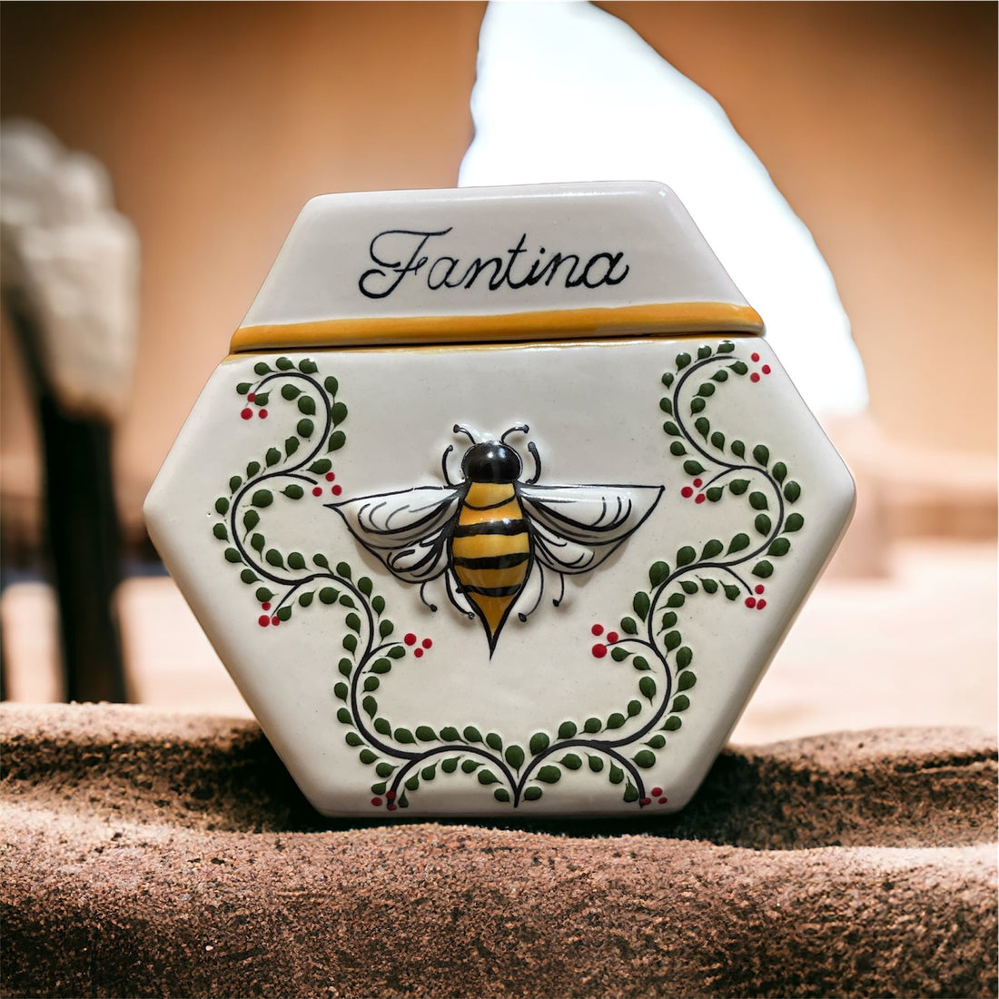 Hand-painted Fantina ceramic vessel with raised bee, on a warm earthen surface