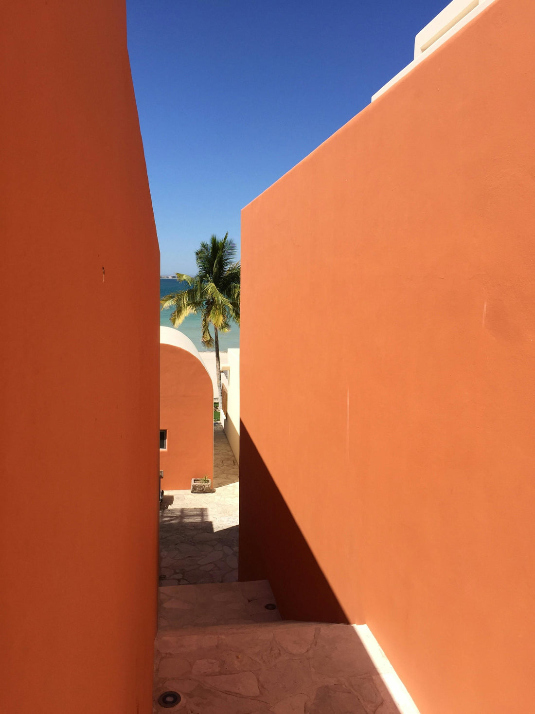Arquitectura mexicana contemporánea en muros de barro naranja frente al mar
