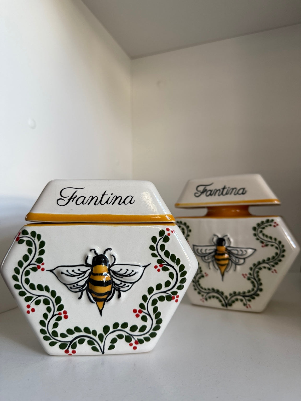 Two Enredadera vessels side by side. The freehand vine is painted differently on each, which is what freehand means.