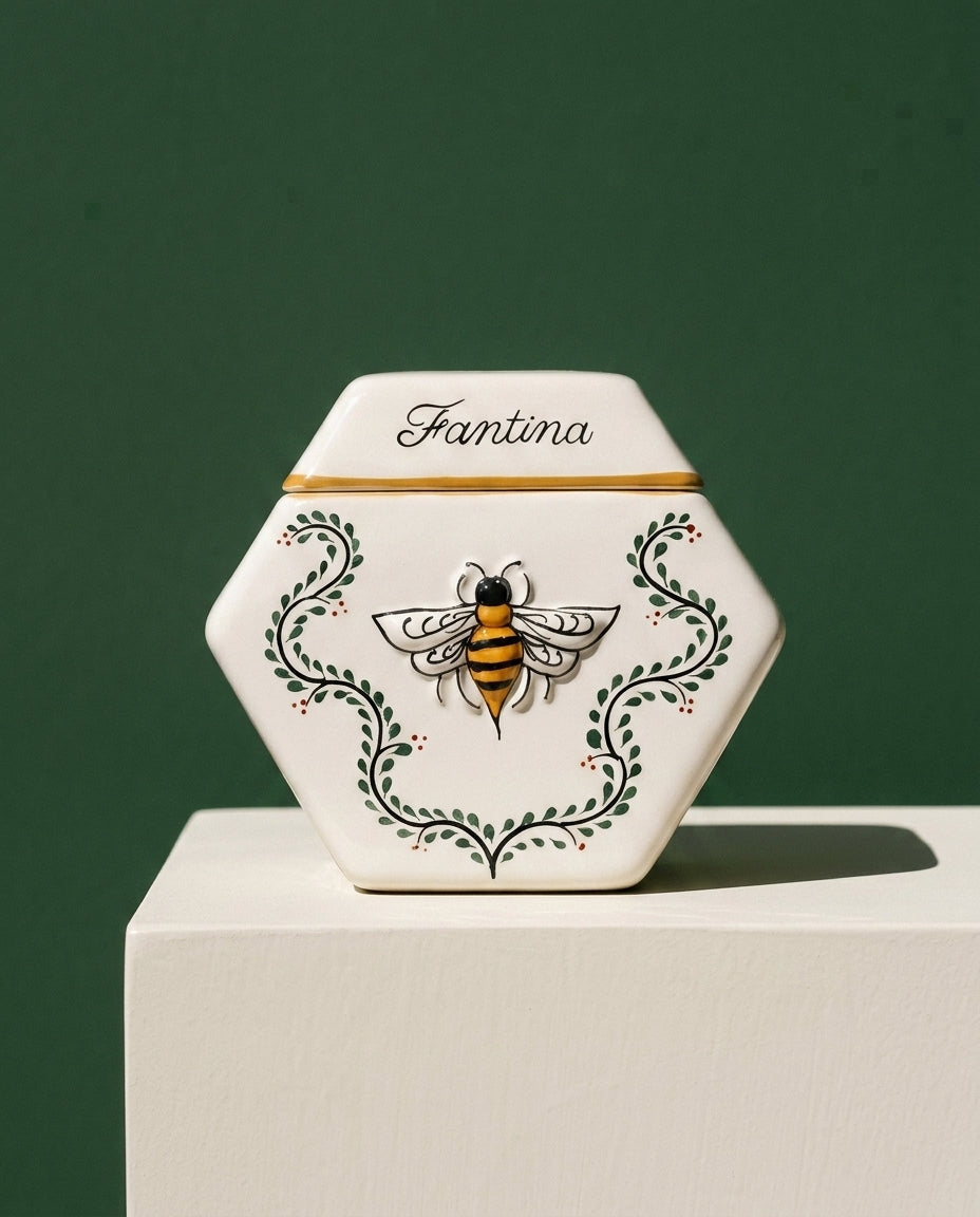 Enredadera vessel on a bone-white plinth against a deep green wall. Hand-painted Mexican ceramic holding raw mesquite honey from Jalisco.